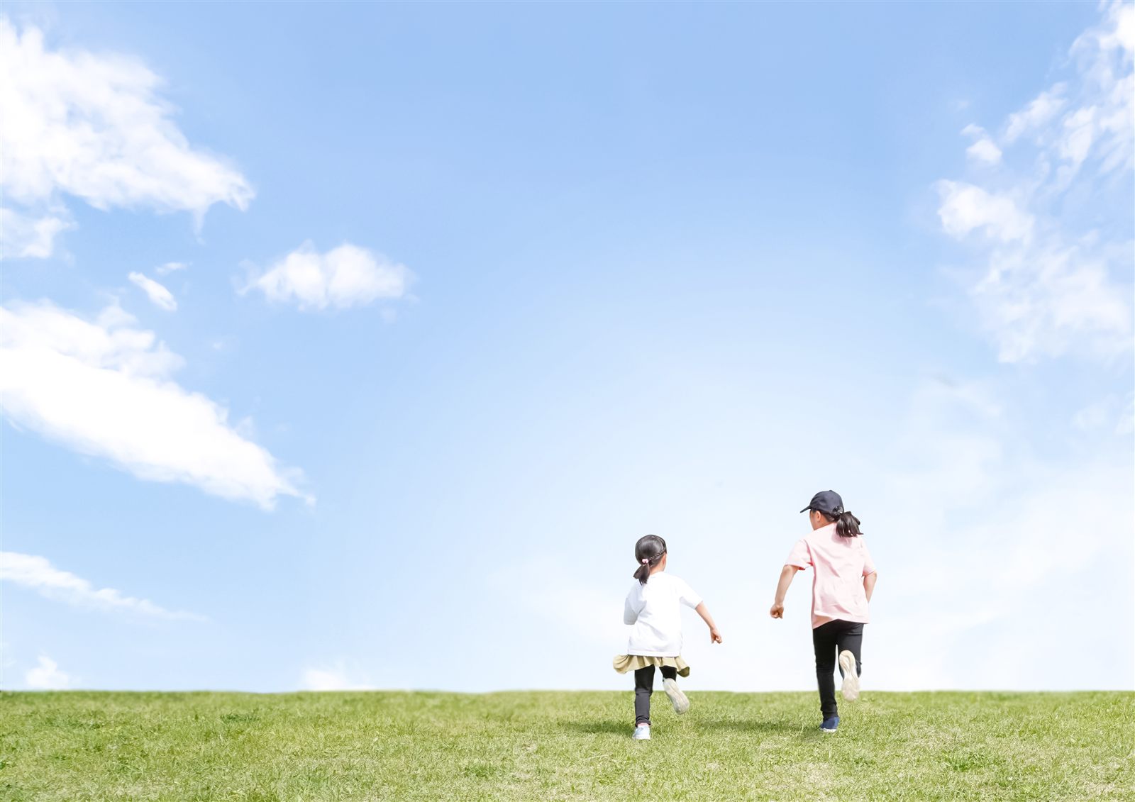 草原を走る子どもたちの後ろ姿